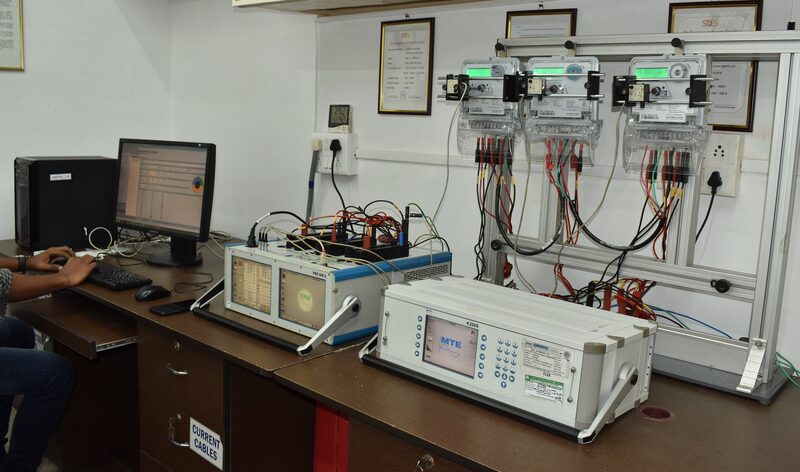 Technician operating energy meter calibration bench with MTE PRS 600.3 and K2006 reference standards